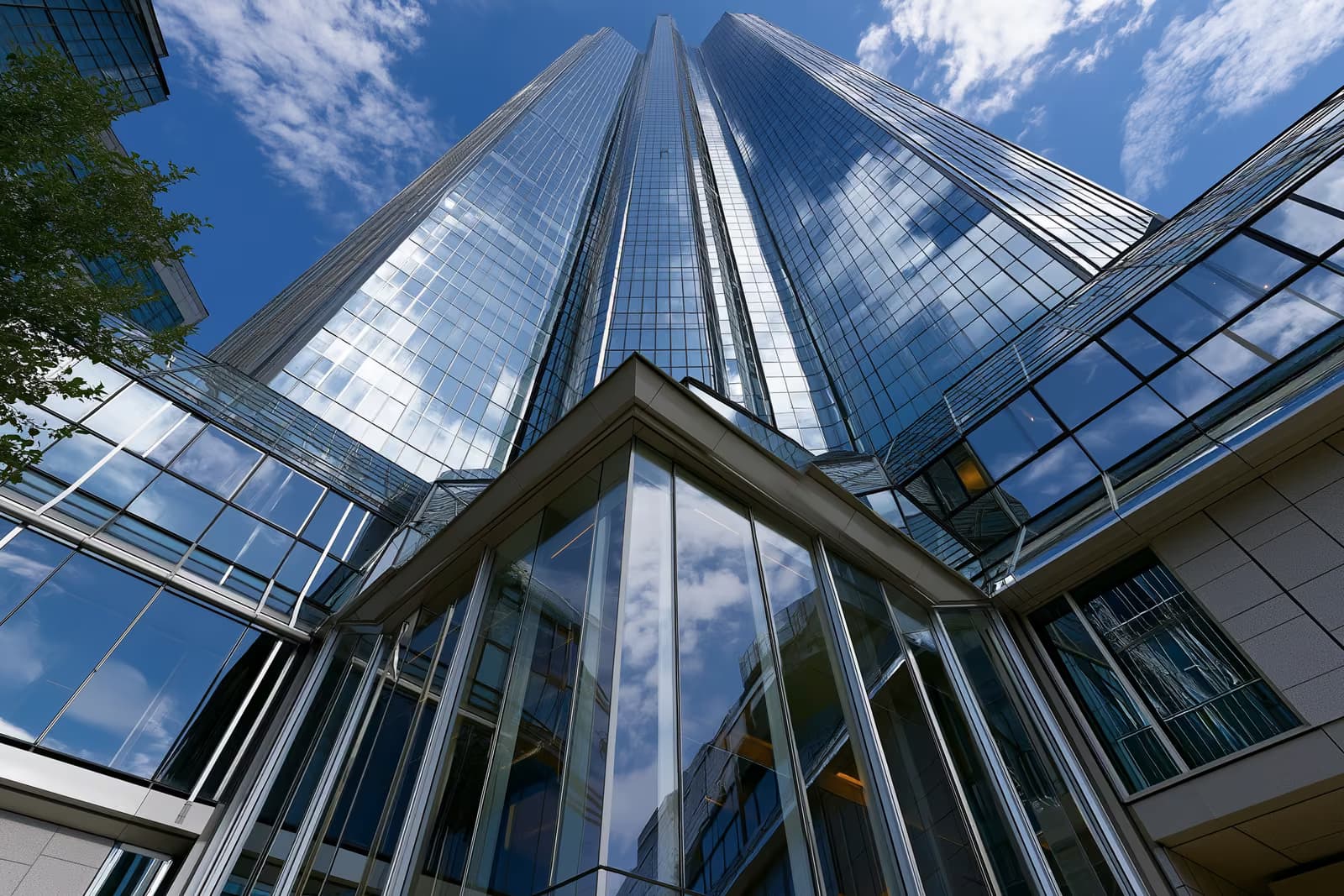 Una moderna torre bancaria in vetro nel quartiere finanziario tedesco, sotto un cielo limpido.