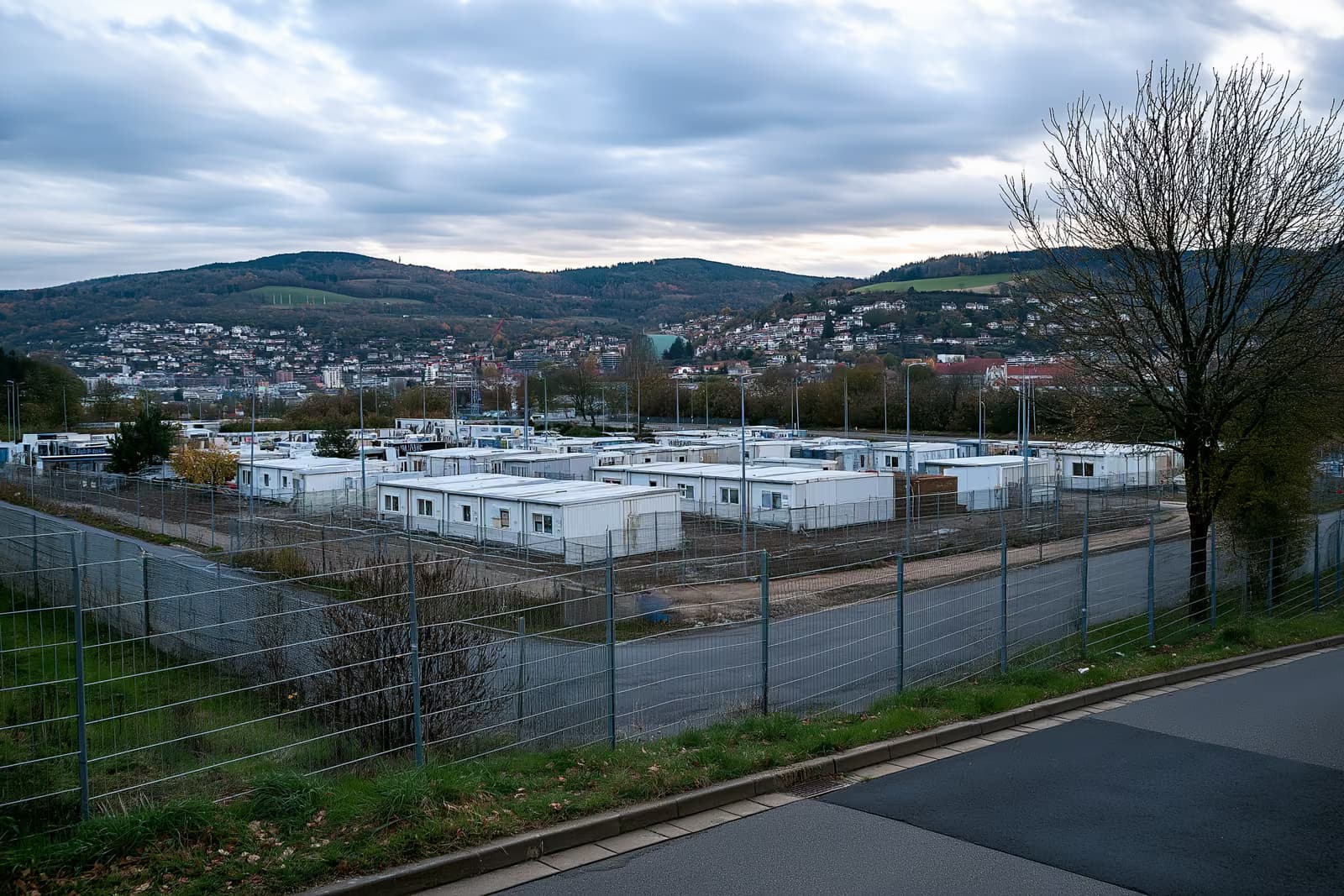 Un complesso residenziale recintato con edifici realizzati con container, situato alla periferia di una città tedesca.